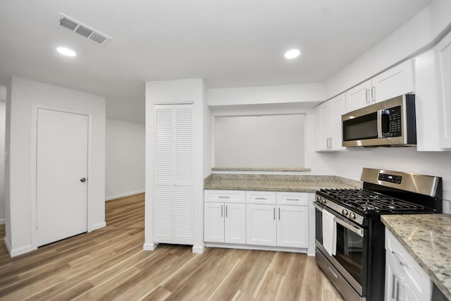 kitchen featuring stainless steel appliances, white cabinetry, light wood-type flooring, and recessed lighting