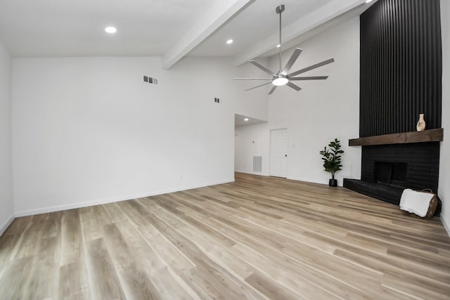 unfurnished living room with a ceiling fan, beamed ceiling, recessed lighting, a fireplace, and light wood-style flooring