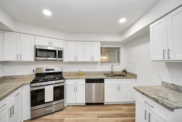 kitchen with appliances with stainless steel finishes, white cabinetry, and recessed lighting