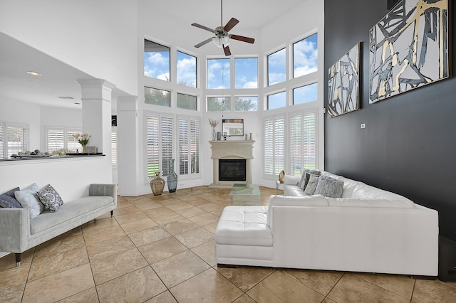 2703 Marble Brook Ln, Pearland, TX 77584 - living room featuring a ceiling fan, a high ceiling, and a glass covered fireplace