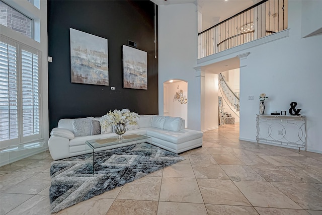 2703 Marble Brook Ln, Pearland, TX 77584 - living room with arched walkways, baseboards, a high ceiling, stairs, and a wealth of natural light