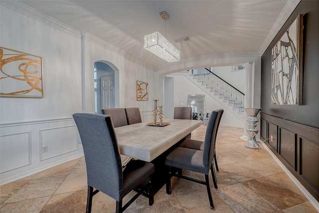 2703 Marble Brook Ln, Pearland, TX 77584 - dining area with arched walkways, ornamental molding, a decorative wall, stairs, and stone tile floors