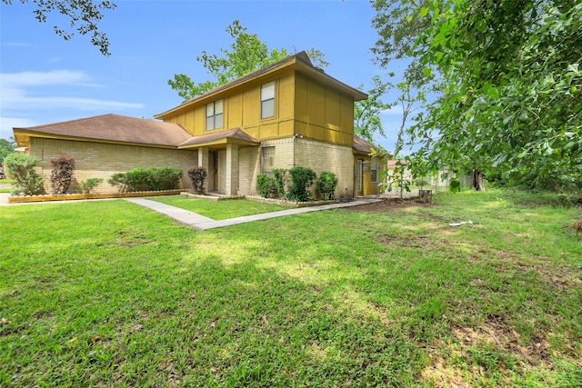 6803 Lakemont Dr, Houston, TX 77050 - view of front facade featuring brick siding, a front lawn, and board and batten siding