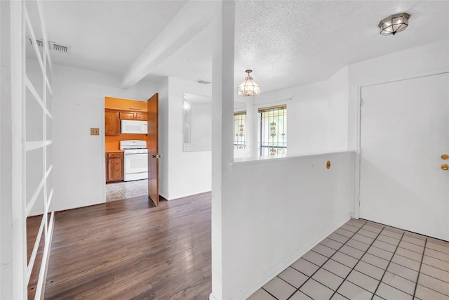 6803 Lakemont Dr, Houston, TX 77050 - interior space with a textured ceiling, visible vents, wood finished floors, a chandelier, and white appliances