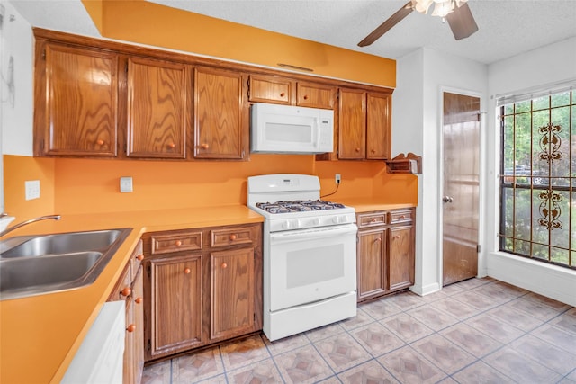 6803 Lakemont Dr, Houston, TX 77050 - kitchen with brown cabinetry, white appliances, ceiling fan, light countertops, and a sink