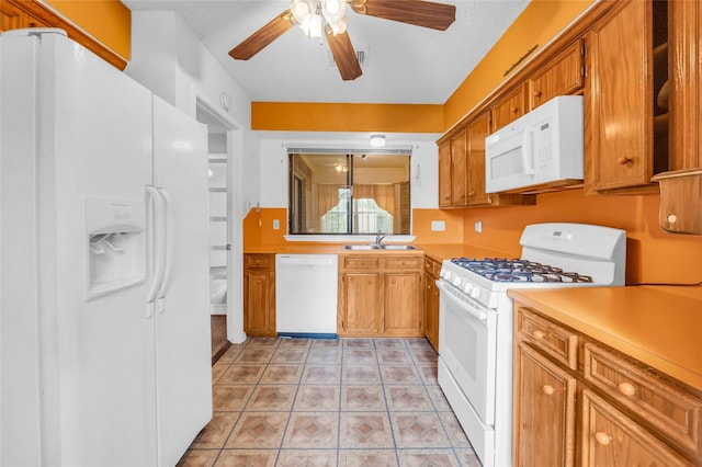 6803 Lakemont Dr, Houston, TX 77050 - kitchen featuring ceiling fan, brown cabinetry, a sink, light countertops, and white appliances