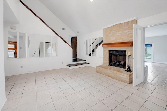 6803 Lakemont Dr, Houston, TX 77050 - unfurnished living room featuring visible vents, stairway, high vaulted ceiling, a large fireplace, and light tile patterned floors