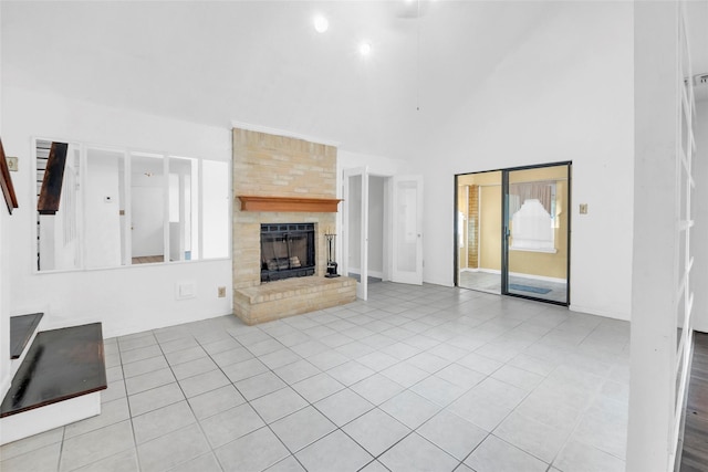 6803 Lakemont Dr, Houston, TX 77050 - unfurnished living room with a healthy amount of sunlight, a large fireplace, tile patterned flooring, and a towering ceiling