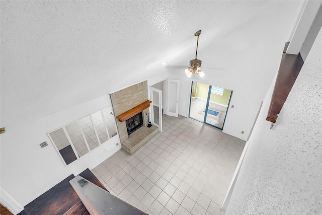 6803 Lakemont Dr, Houston, TX 77050 - unfurnished living room with ceiling fan, a textured ceiling, tile patterned flooring, a fireplace, and vaulted ceiling