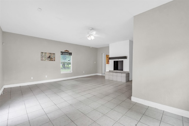 6803 Lakemont Dr, Houston, TX 77050 - unfurnished living room with baseboards, a ceiling fan, light tile patterned floors, and a tile fireplace