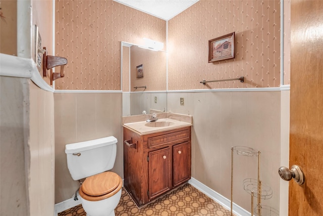 6803 Lakemont Dr, Houston, TX 77050 - bathroom featuring toilet, wallpapered walls, a wainscoted wall, and vanity