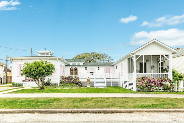 view of front facade with a sunroom and a front yard