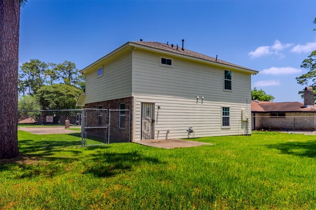 back of house with a gate and brick siding