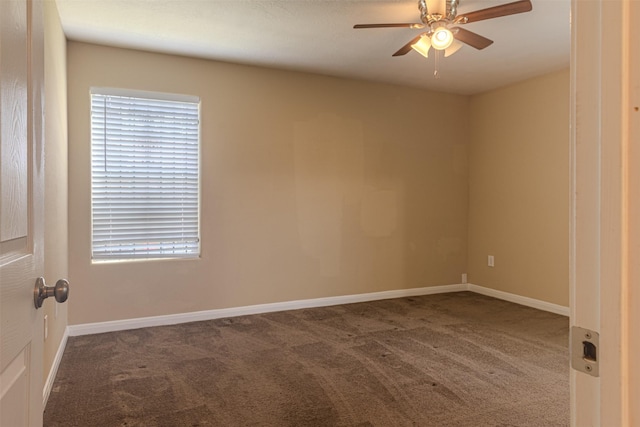 carpeted spare room featuring ceiling fan and baseboards