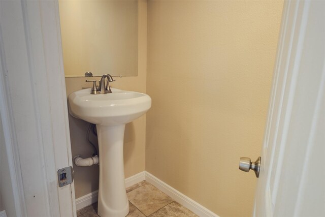 bathroom with a sink, baseboards, and tile patterned flooring