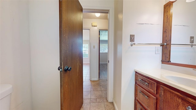 half bathroom featuring vanity, tile patterned flooring, and toilet