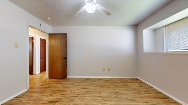 empty room featuring light wood-type flooring, baseboards, and ceiling fan