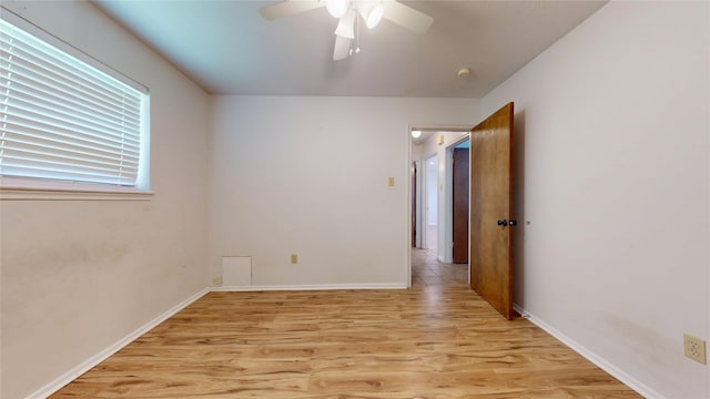 spare room with baseboards, ceiling fan, and light wood-type flooring