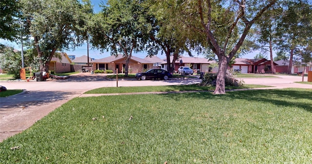 ranch-style home with a residential view, driveway, and a front yard