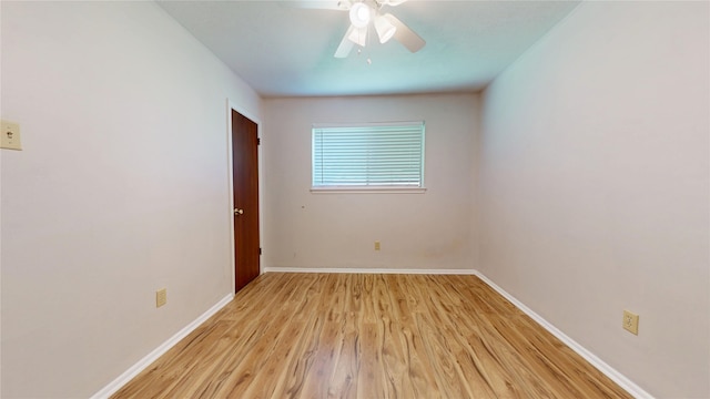 spare room featuring light wood-style floors, baseboards, and ceiling fan