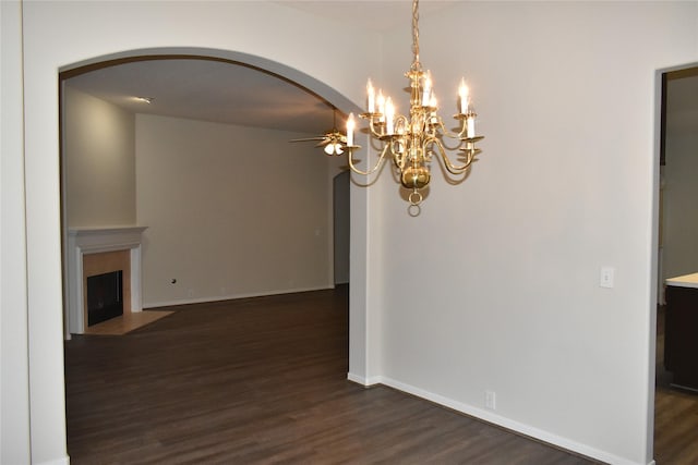 11111 Sprucedale Ct, Houston, TX 77070 - unfurnished dining area with dark wood-style flooring, a fireplace with flush hearth, baseboards, arched walkways, and ceiling fan with notable chandelier