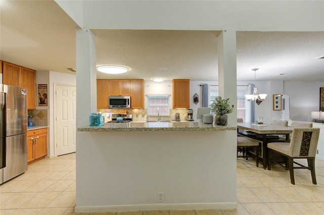 10338 E Summit Canyon Dr, Houston, TX 77095 - kitchen featuring decorative backsplash, a sink, light tile patterned floors, a wealth of natural light, and stainless steel appliances