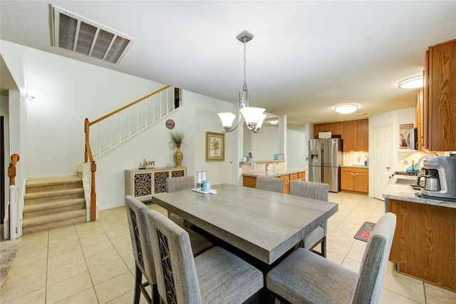 10338 E Summit Canyon Dr, Houston, TX 77095 - dining space featuring stairs, light tile patterned flooring, a notable chandelier, and visible vents