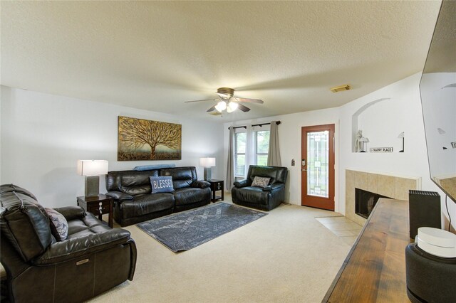 10338 E Summit Canyon Dr, Houston, TX 77095 - living room with ceiling fan, a textured ceiling, carpet, a tile fireplace, and visible vents
