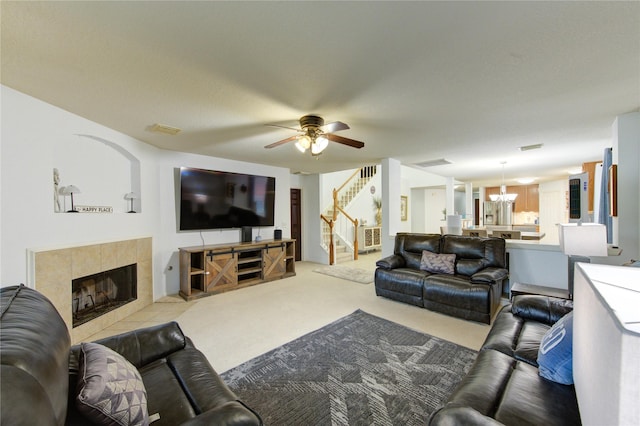 10338 E Summit Canyon Dr, Houston, TX 77095 - living room with visible vents, a fireplace, stairway, carpet, and ceiling fan with notable chandelier