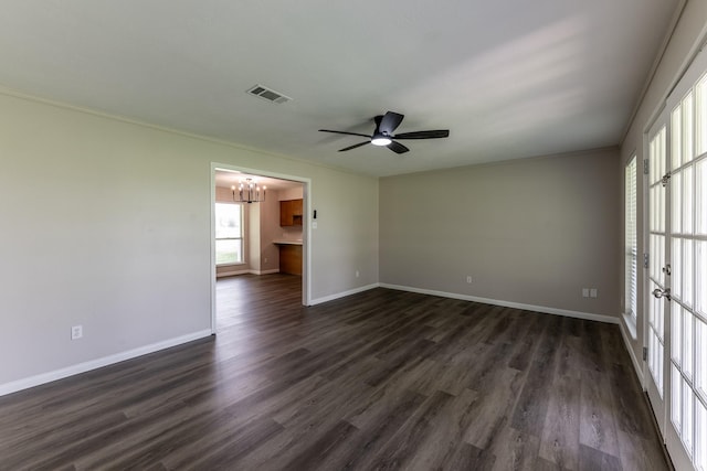 unfurnished room featuring visible vents, baseboards, ceiling fan with notable chandelier, and dark wood-style floors