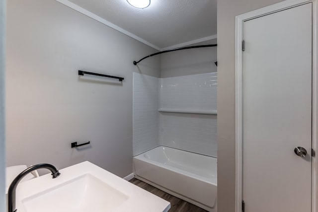 full bath with a sink, bathing tub / shower combination, crown molding, and wood finished floors