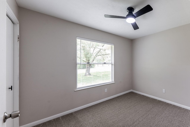 carpeted spare room with ceiling fan and baseboards