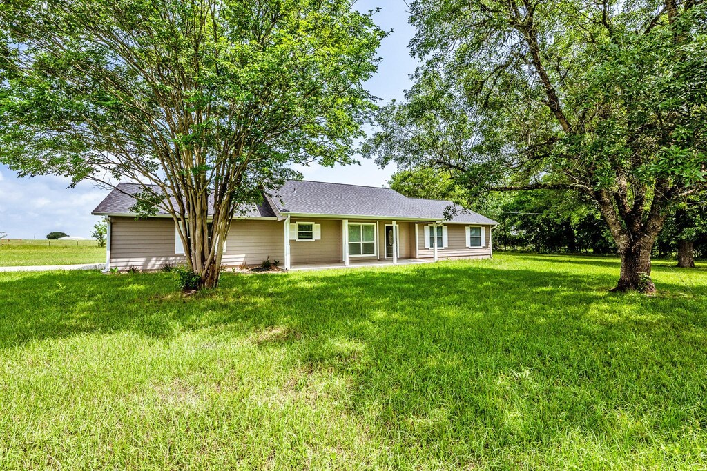 5024 State Highway 30, Huntsville, TX 77320 - view of front of home featuring a front lawn, a patio area, and roof with shingles