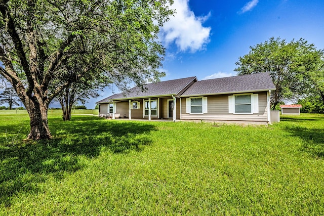 single story home with a patio, a front lawn, and roof with shingles