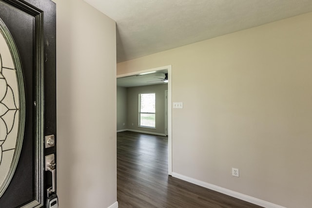 entryway featuring a ceiling fan, baseboards, and dark wood-style floors