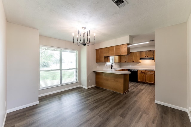 kitchen featuring visible vents, black dishwasher, brown cabinets, a sink, and a notable chandelier