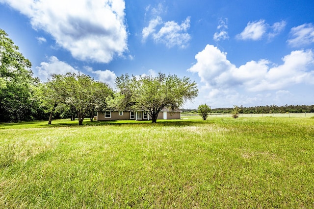 view of yard with a rural view and fence