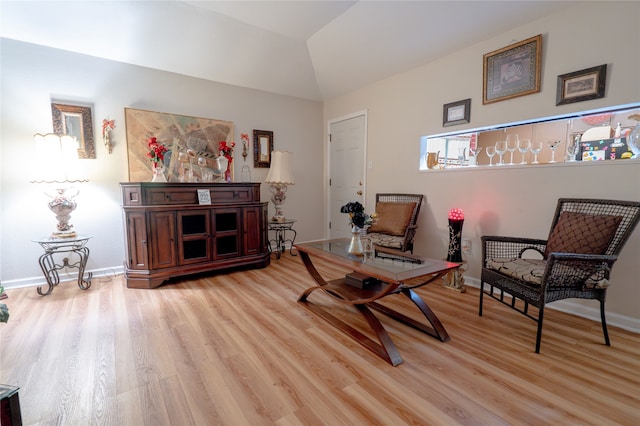 sitting room featuring baseboards, light wood-style flooring, and lofted ceiling