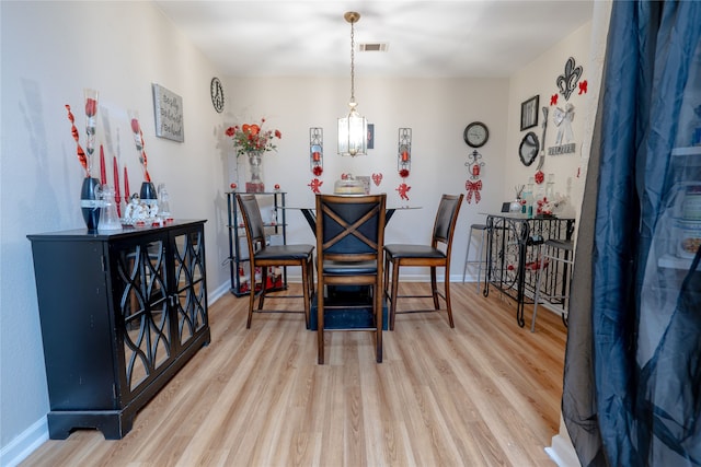 dining room featuring baseboards, visible vents, and wood finished floors