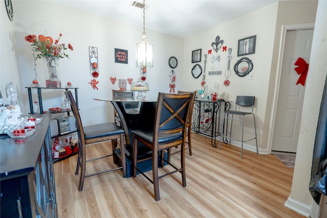 dining space with baseboards, visible vents, and wood finished floors