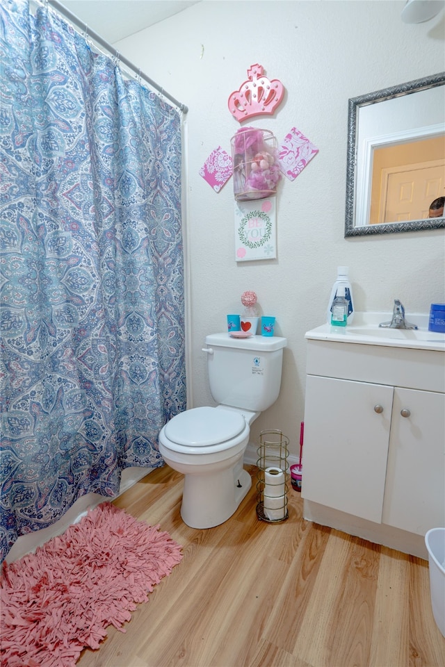 bathroom featuring vanity, a shower with shower curtain, wood finished floors, and toilet
