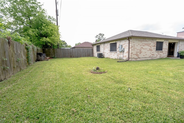 view of yard featuring central AC unit and a fenced backyard