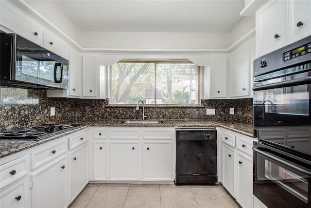 kitchen featuring light tile patterned flooring, a sink, white cabinetry, decorative backsplash, and black appliances