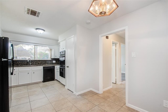 kitchen featuring backsplash, visible vents, black appliances, light tile patterned flooring, and white cabinetry