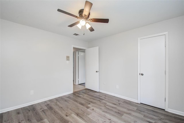 unfurnished bedroom with ceiling fan, baseboards, visible vents, and wood finished floors