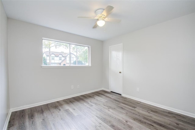 unfurnished room with baseboards, a ceiling fan, and wood finished floors