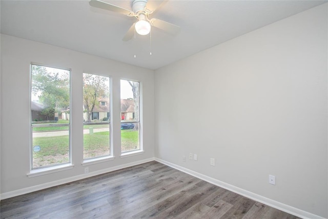 spare room with baseboards, a ceiling fan, and wood finished floors
