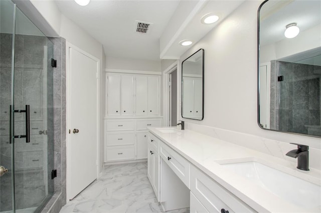 bathroom featuring a shower stall, a sink, and marble finish floor