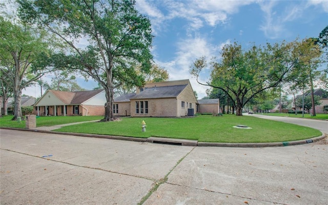 view of property exterior featuring a lawn, cooling unit, and brick siding