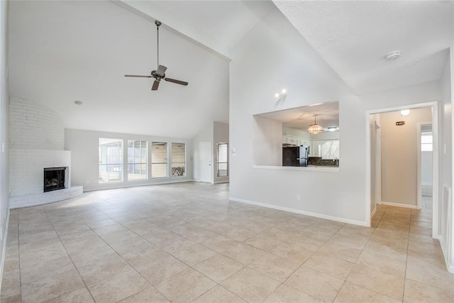 unfurnished living room with ceiling fan, a fireplace, high vaulted ceiling, baseboards, and light tile patterned floors
